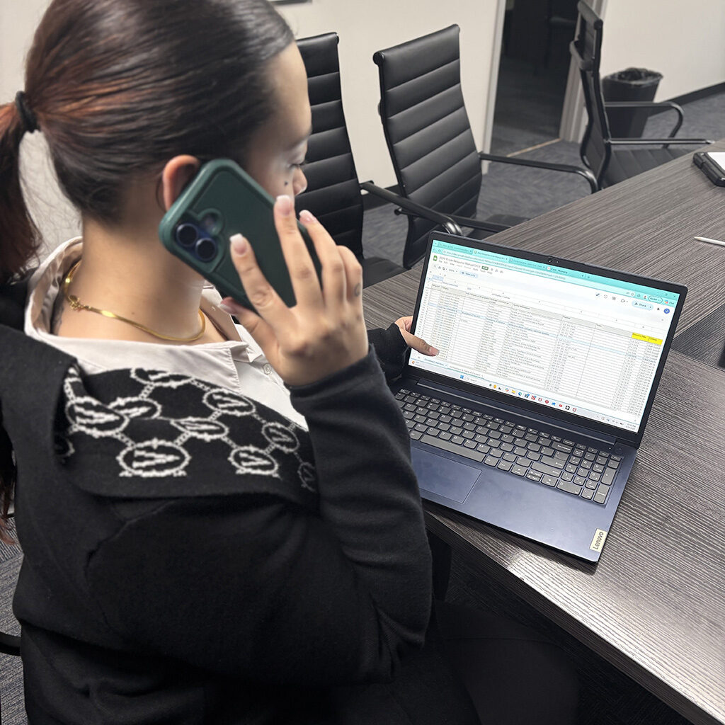 a helpline volunteer answering the phone in front of a computer