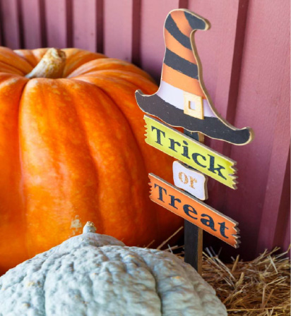 Trick-or-Treat sign next to a pumpkin